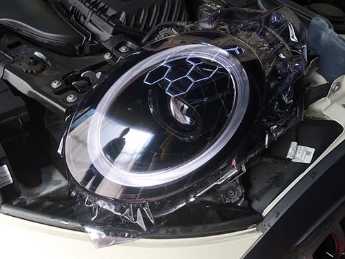 ヘッドライトレンズへ専用のプロテクションフィルムを貼り付け
